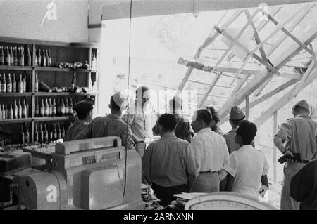 Building collapsed (Stone & Roof Factory (v/h.. Pere?) , seen from a room where bottles are in cabinets Date: December 1948 Location: Indonesia, Dutch East Indies Stock Photo