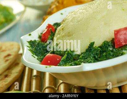 Ugali Sukuma Wiki, made with collard greens, known as sukuma, cooked with onions and spices. Kenyan cuisine, Traditional assorted African dishes, Top Stock Photo