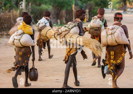 Hamer tribal people crossing the road in Dimeka village, Omo river valley, Ethiopia Stock Photo