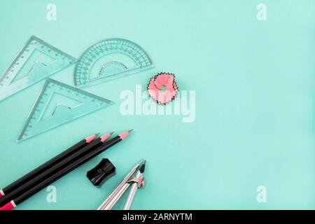 bunch of black wooden pencils along with a pencil sharpener ,a pencil compass with a silver pencil,,,some measuring tools,and some pencil shavings Stock Photo