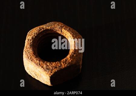 Large old rusty nut close up on black background Stock Photo