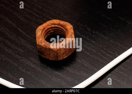 Large old rusty nut close up on black background Stock Photo