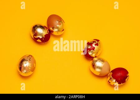 Assorted golden chicken eggs on a yellow background. Easter greeting card. Stock Photo