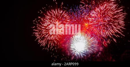 Large expanding red, white, blue,and gold starburst fireworks photographed against a black sky on the Fourth of July in Minnesota Stock Photo