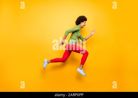 Full length body size profile side view of nice attractive lovely cheerful cheery wavy-haired girl jumping running active life isolated over bright Stock Photo