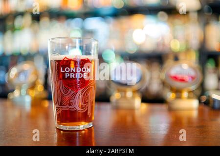 Portsmouth, United Kingdom - November 2, 2019: Glass of cold London Pride beer served in British pub Stock Photo