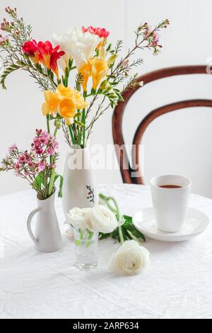Coffee table styling with colorful spring flowers. Spring still life composition. Morning coffee with flowers Stock Photo