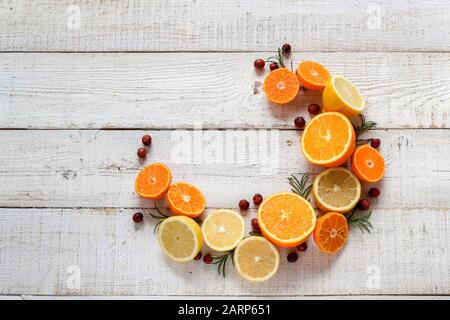 Colorful citrus fruits styled in a half circle with an empty space for your product or text on a white wooden table Stock Photo
