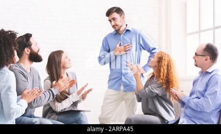 Young man appreciating support at group therapy session in rehab Stock Photo