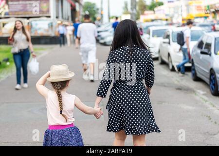 mom and daughter are walking by the handle along the streets of the city Stock Photo