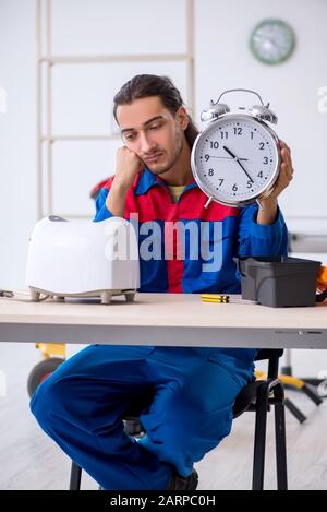 The young male contractor repairing toaster at workshop Stock Photo