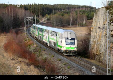 Modern VR Group electric 2 storey passenger train at speed in winter, elevated view from bridge. Salo, Finland. January 25, 2020. Stock Photo