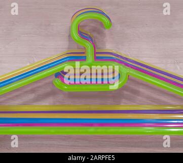 set of colored plastic clothes hangers on neutral wooden background Stock Photo