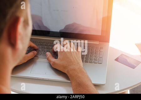 Man's hands on the keyboard of the laptop close-up. Stock Photo