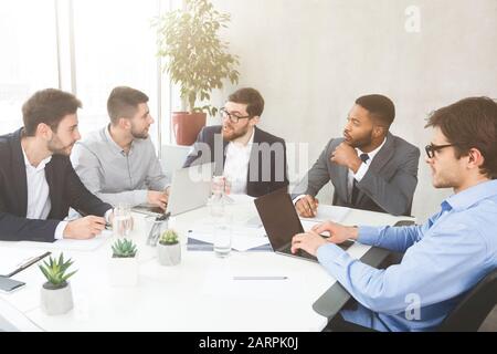 Businessmen having group meeting, discussing new project Stock Photo