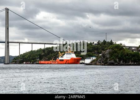 Offshore supply AHTS vessel Normand Ranger moored near Askoey (Askøy) suspension bridge. Outside port of Bergen, Norway Stock Photo