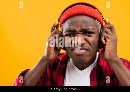 closeup portrait of an embarrassed stylish black man in red headphones. Stock Photo
