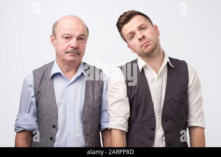 Two mature men father and son being sad and tired. Negative facial emotion Stock Photo
