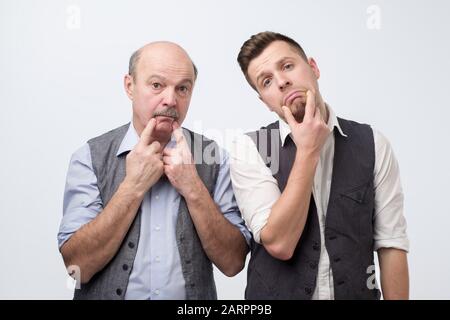 Two mature men father and son being sad and tired. Negative facial emotion Stock Photo