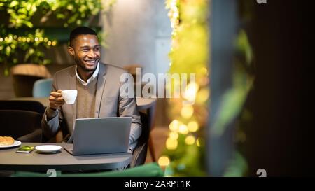 Afro manager drinking tea and using personal computer Stock Photo