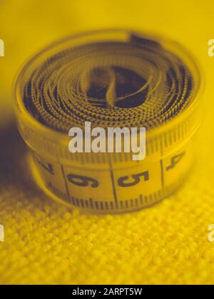 Yellow measuring tape in round plastic box on the towel. Stock Photo