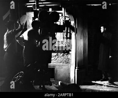 ORSON WELLES as Harry Lime filming his first appearance in Vienna doorway at London Film Studios Shepperton England with camera crew for  THE THIRD MAN 1949 director CAROL REED screenplay GRAHAM GREENE cinematographer ROBERT KRASKER producer ALEXANDER KORDA London Film Productions / British Lion Film Corporation Stock Photo