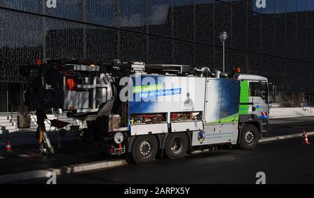 Berlin, Germany. 28th Jan, 2020. A special vehicle from Berliner Wasserbetriebe is standing in front of the Axel Springer building in Berlin-Mitte for sewer work; a worker walks past with a wheelbarrow against the light. Credit: Sonja Wurtscheid/dpa/Alamy Live News Stock Photo