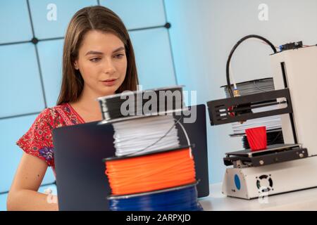 Young female designer works with a home 3D printer Stock Photo