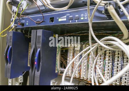 Equipment for ip telephony is installed in the switch box. Internet phone patch panel. Communication modules and a lot of wires are on the technical s Stock Photo