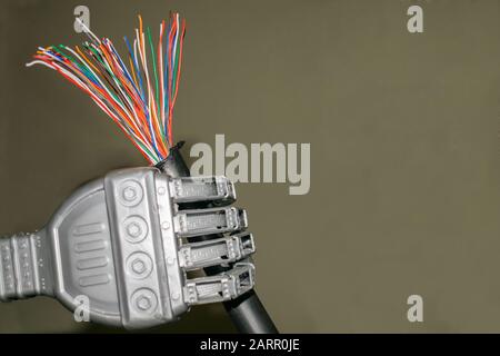 The trunk colored telephone cable is in the robot's hand. Damaged Internet cable close-up Stock Photo