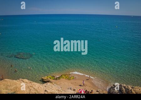 Beach line of the coast with vacationing tourists on a hot summer day in Spain Stock Photo