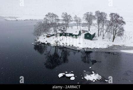 View of snow covered landscape of Loch Ossian and Loch Ossian Youth Hostel in Highland Region, Scotland, UK Stock Photo