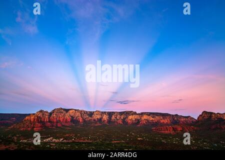Anticrepuscular rays at sunset over the red rocks in Sedona, Arizona, USA Stock Photo
