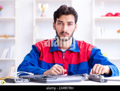 Repairman working in technical support fixing computer laptop troubleshooting Stock Photo
