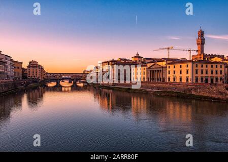 Firenze, Tuscany, Italy. Postcard image at sunset of Florence. The Arno river, the Ponte Vecchio and, on the left, the Palazzo Vecchio tower Stock Photo