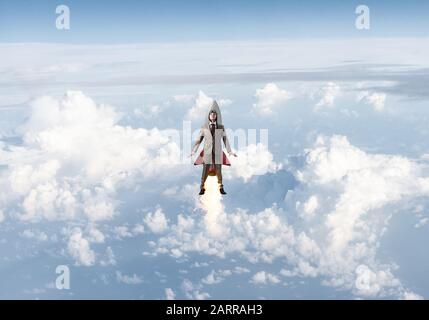 Business person in aviator hat flying on rocket Stock Photo