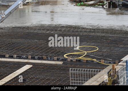 Pouring cement to make reinforced concrete over rebar on a working construction site during a new building project Stock Photo