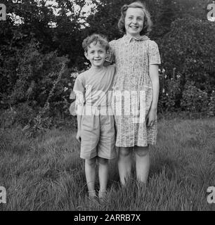 https://l450v.alamy.com/450v/2arrb7x/1950s-historical-posing-for-a-picture-a-happy-brother-and-sister-standing-together-outside-in-a-grassy-field-england-uk-2arrb7x.jpg