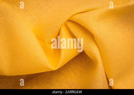 Checkered surface of stockinette. Creases of natural rippled stockinette, yellow textile. Fabric pattern, material Stock Photo