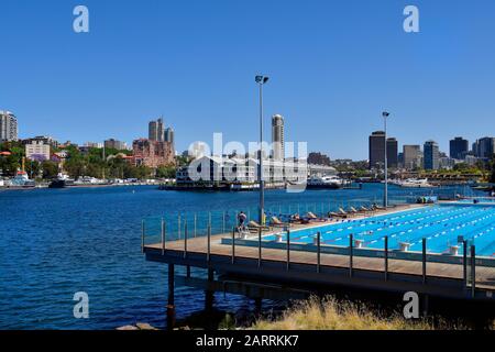 Sydney, NSW, Australia - October 31, 2017: Unidentified people in harborside swimming pool and yachts in Woolloomooloo Finger Wharf, Horizon apartments b Stock Photo