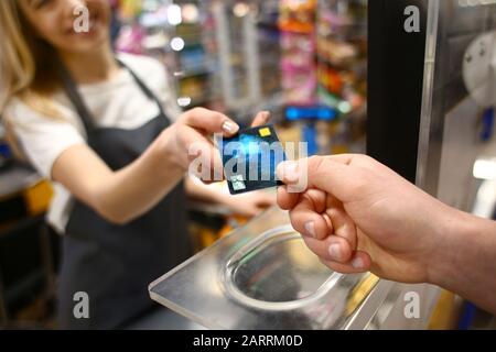 Young man paying for goods in supermarket, closeup Stock Photo