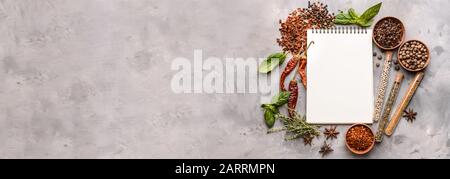 Empty notebook and different spices on grunge background with space for text Stock Photo
