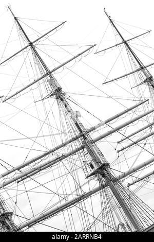 Monochrome image of mast with rigging and rolled up sails of old polish sailing ship Dar Pomorza Stock Photo