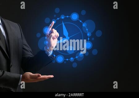 Businessman with drawn clock against dark background Stock Photo
