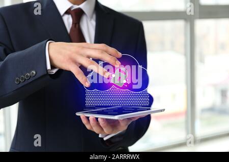 Businessman with tablet computer using cloud storage service in office, closeup Stock Photo