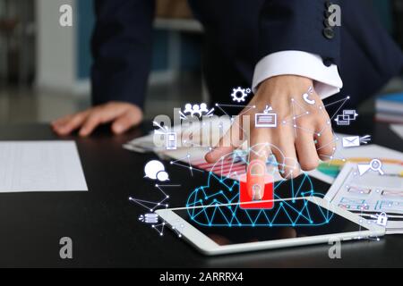 Businessman with tablet computer using cloud storage service in office, closeup Stock Photo