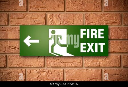 Sign of emergency fire exit on brick wall Stock Photo