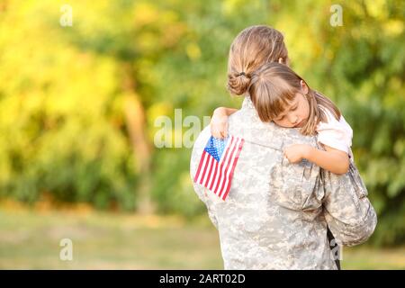 Military man hugging his little daughter outdoors Stock Photo