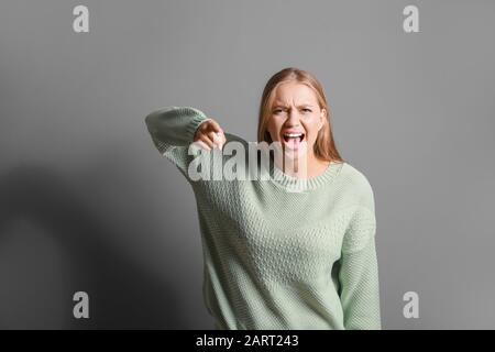 Portrait of angry woman on grey background Stock Photo