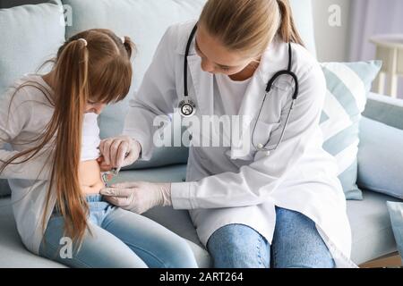 Doctor giving diabetic girl insulin injection at home Stock Photo